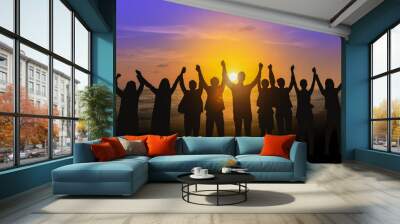 Silhouette of happy business team making high hands in sunset sky background for business teamwork concept Wall mural