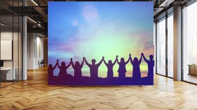 Silhouette of happy teamwork hold hands up as a business successful, victory. Business goal achievement, hit company target. Teamwork commitment and successful concept. Wall mural