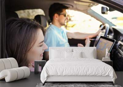 A young man holding his girlfriend’s hand in a car and driving  Wall mural