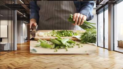 Women’s hands cut fresh green onion salad on the kitchen table Wall mural