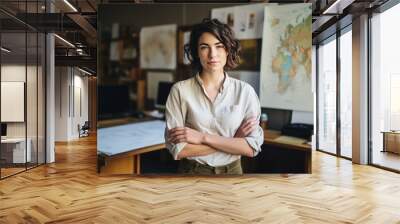 Casual portrait of a designer in her office standing by her desk, daylight coming through the window, corporate photography.  Wall mural