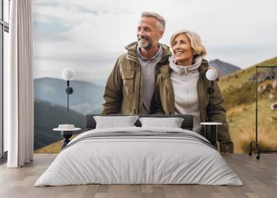 Senior couple admiring the scenic Pacific coast while hiking, filled with wonder at the beauty of nature during their active retirement. Exploring the great outdoors in the mountains, active lifestyle Wall mural