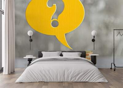 A speech bubble with a question mark in yellow balancing over mixed coin piles.  Wall mural