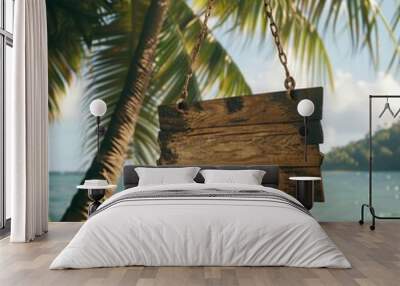 A weathered wooden signboard suspended from a palm tree on a tropical beach, with a lush, green jungle in the background. Wall mural