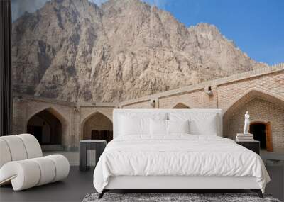 Mountain behind the historical brick walls of persian caravanserai with wide empty courtyard under the sun Wall mural