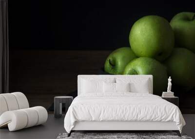 fresh green apple with droplets of water in bowl against black background Wall mural