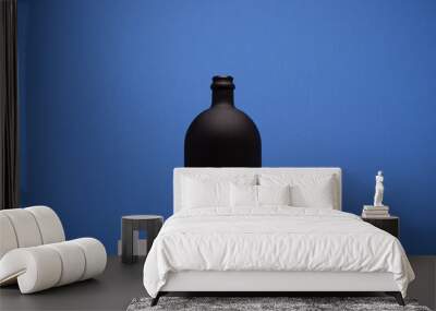 Black wine bottle on the blue background Wall mural