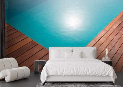 Diagonal lines of exotic hardwood in detail decking around the blue water swimming pool corner Wall mural