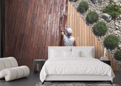 Wood deck renovation treatment, the person applying protective wood stain with a brush, overhead view of ipe hardwood decking restoration process Wall mural