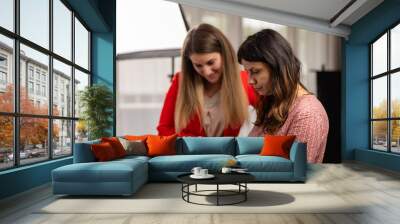 Two women in the studio looking at the laptop Wall mural