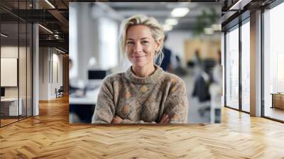 Professional woman standing in her office while looking at camera and smiling Wall mural