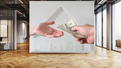 Two people passing money against a white house Wall mural