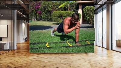 Latin man performing push-ups with shoulder tap Wall mural