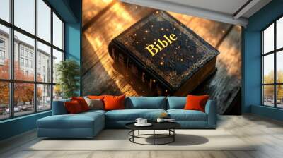 Holy Bible on a wooden table illuminated by warm light. Wall mural