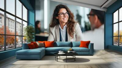 Smiling Young Business Woman Listening to Her Partner in Coworking Space Wall mural