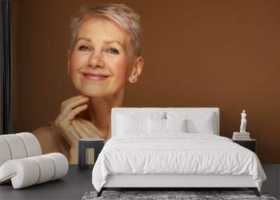 Beauty portrait of mature woman smiling with hand on face. Wall mural