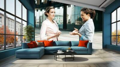 Business, people and lifestyle concept: Two diverse businesswomen. Excited afro female sharing ideas or startup business plan with blond woman. Informal conversation, work break concept Wall mural