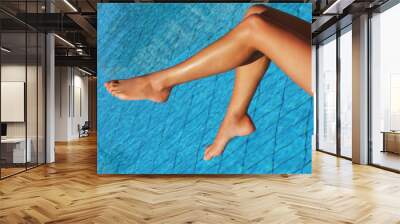 female legs at blue water of swimming pool Wall mural