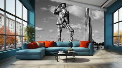 handsome fashion male model dressed in elegant suit posing outdooe. Long haired Metrosexual. Black and white picture. Wall mural