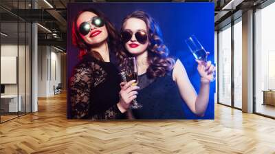 Lifestyle, friendship and party concept: two women in black dresses drinking wine and dancing Wall mural