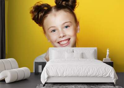 portrait of cheerful smiling little girl on yellow background Wall mural