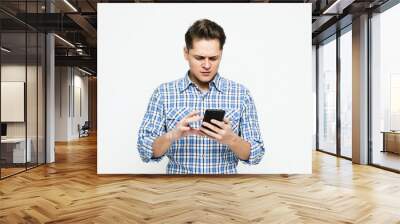 Portrait of nice confident calm handsome attractive trendy man with wearing blue shirt holding in hands phone Wall mural