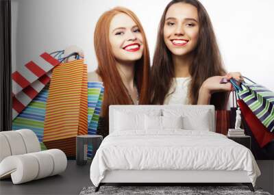 Portrait of two Beautiful young women with shopping bags Wall mural