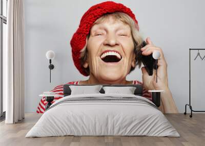 technology, communication age and people concept: happy senior woman with smartphoneover white background Wall mural