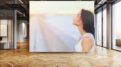 Side view profile portrait of a happy brunette woman relaxing breathing fresh air outdoors in summer Girl close eyes doing deep breath exercises. Positive emotion success, peace of mind, zen concept. Wall mural