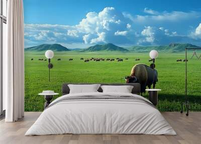 A bison grazing peacefully in a green meadow with rolling hills and a blue sky. Wall mural