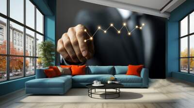 A businessman touches a glowing growth chart, tracing the line of success. Wall mural