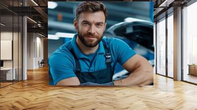 A confident auto mechanic, dressed in blue, repairs a car in a bustling garage. Wall mural