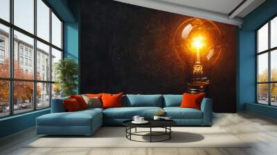 A glowing light bulb on a dark background, symbolizing inspiration, ideas, and innovation. Wall mural