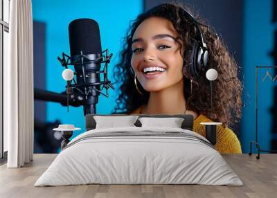 A happy woman sings her heart out into a microphone in a cozy recording studio. Wall mural