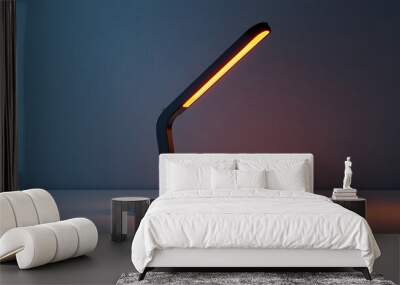 A modern desk lamp casts a warm, inviting glow against a blue background. Wall mural