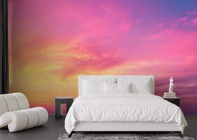 A vibrant pink and yellow sunset sky glows over the ocean, casting a warm, dreamy light across the horizon. Wall mural