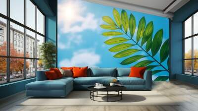 Lush green leaves stand out against a bright blue sky, basking in sunlight. Wall mural