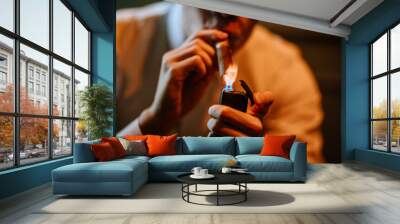 Valmiera, Latvia - September 9, 2023 -  Close-up of a person lighting a cigar with a lighter, showcasing a detailed and intimate moment of cigar smoking. Wall mural