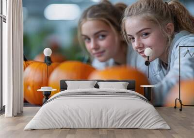 Two Young Women Peek Over Pumpkins Wall mural