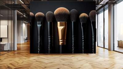 Makeup brushes with black and gold handles standing on dark background Wall mural