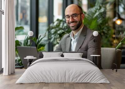 Smiling businessman working on laptop in modern office setting, Generative AI Wall mural