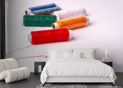 Colorful sewing thread set and needles isolated on background. Wall mural