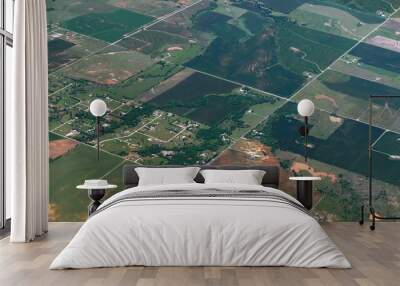 Wide aerial view of green sprawling farmlands enroute to Dallas seen from an airplane window Wall mural