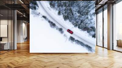 Aerial top view of snow covered forest and lake with winter road and red car. Drone photography landscape. Wall mural