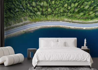 Beautiful aerial view of road between green summer forest and blue lake in Lapland. Wall mural