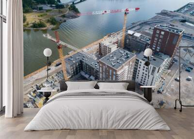 View of a construction crane from above looking down onto a metropolitan city scape during daytime Wall mural