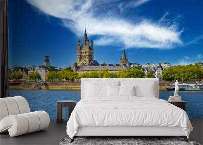 Cologne (Martins Viertel), Germany - July 9. 2022: Beautiful scenic rhine riverside water skyline, medieval St. Martin church, green trees, spectacular blue summer sky Wall mural