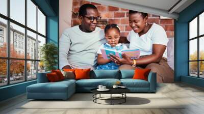 Family, happy and reading a book on a home sofa with glasses for learning, knowledge and time together. A man, woman and girl kid in a lounge with love, care and happiness with a story in house Wall mural