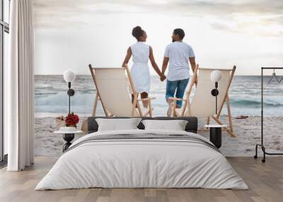 Sunset, black couple and break with beach chair, holding hands or celebrating for anniversary. Vacation, picnic and people travel for marriage on honeymoon, summer holiday and happy bonding in Miami Wall mural