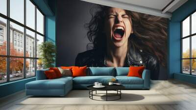 Portrait of a beautiful rocker woman in a black leather jacket on a studio background. Screaming girl isolted exemplifies youthful rebellion, alternative fashion, self-expression Wall mural